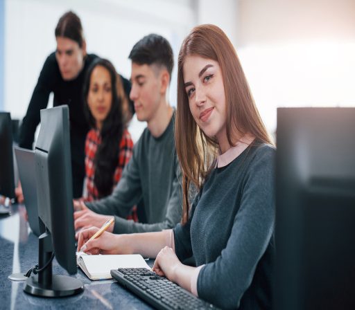 Pretty girl. Group of young people in casual clothes working in the modern office.